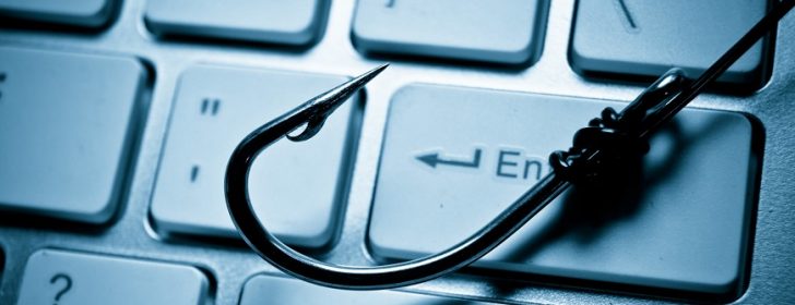 phishing a fish hook on computer keyboard representing phishing attack on computer system
